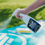 Person spaying the iROCKER Paddle Board Cleaner & Protectant to their board | Lifestyle