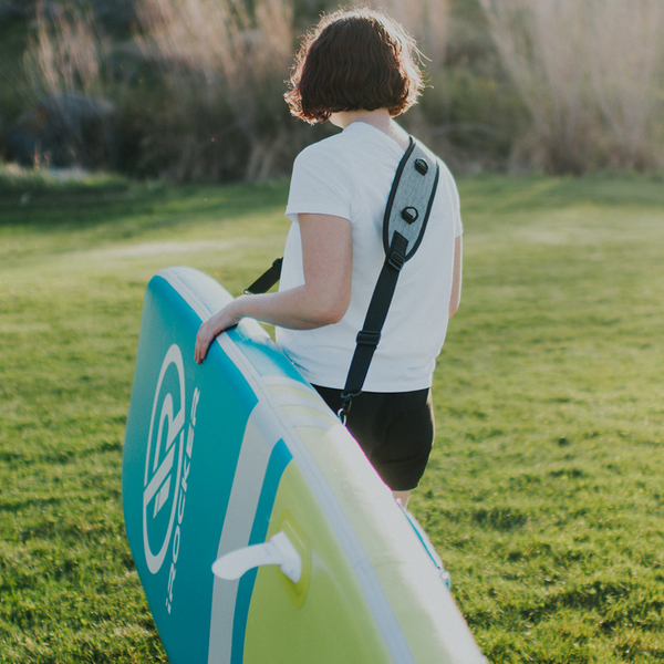 Person carrying paddle board with paddle board straps  Lifestyle