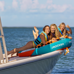 Three young women on top of a boat sitting on a orange towable | Lifestyle